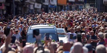 Los fanáticos de Bonnie Tyler se alinean en las calles de un pueblo galés mientras traen su ataúd a casa. Los fanáticos de Bonnie Tyler se alinean en las calles de un pueblo galés mientras traen su ataúd a casa.