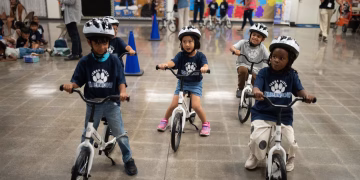 Un rito infantil se traslada al interior mientras los niños de jardín de infantes aprenden a andar en bicicleta en los gimnasios escolares